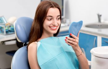 the patient smiles in a dental chair