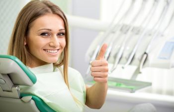 the patient smiles in a dental chair
