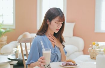 asian woman eat high sugar content food and has Gastroesophageal Reflux Disease feel uncomfortable